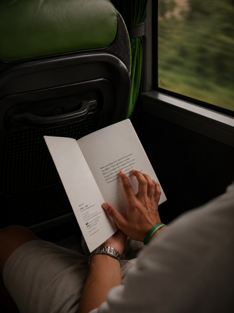 Nuotraukoje vyras autobuse skaito knygą